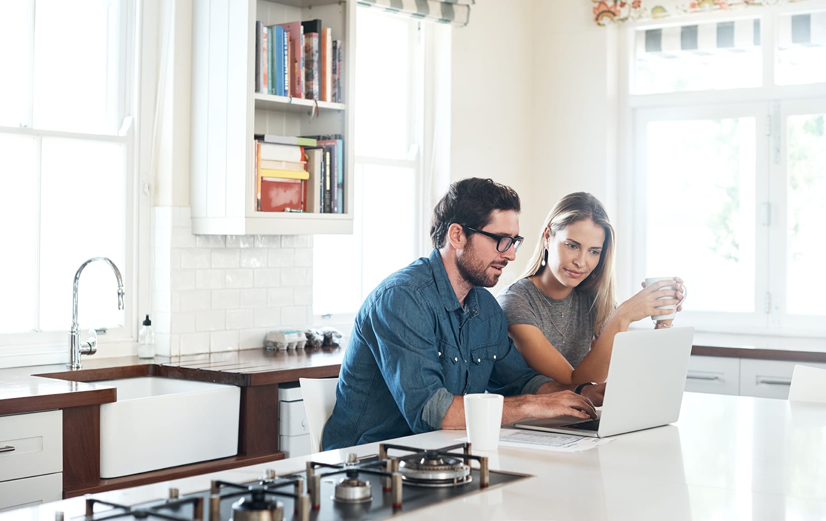 couple in kitchen using laptop