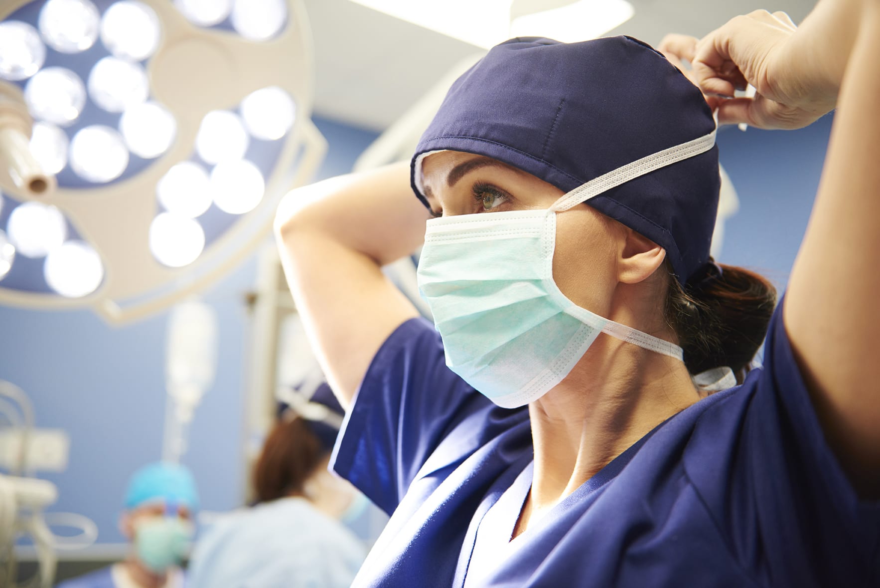 Nurse in OR putting mask on