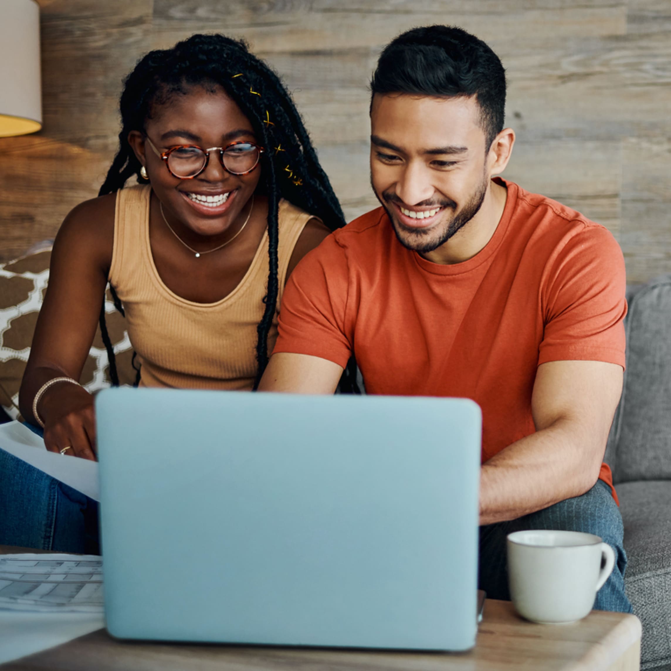 Happy couple sitting in front of computer and talking together.