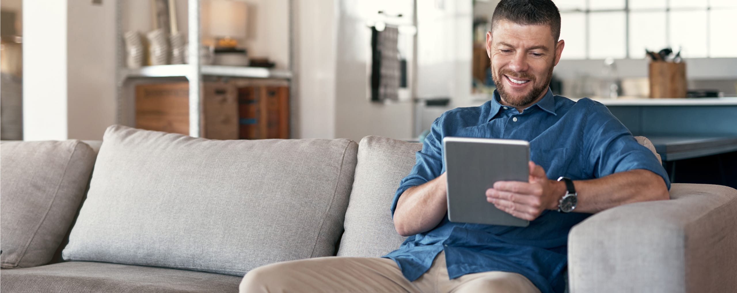 man on a couch looking at ipad