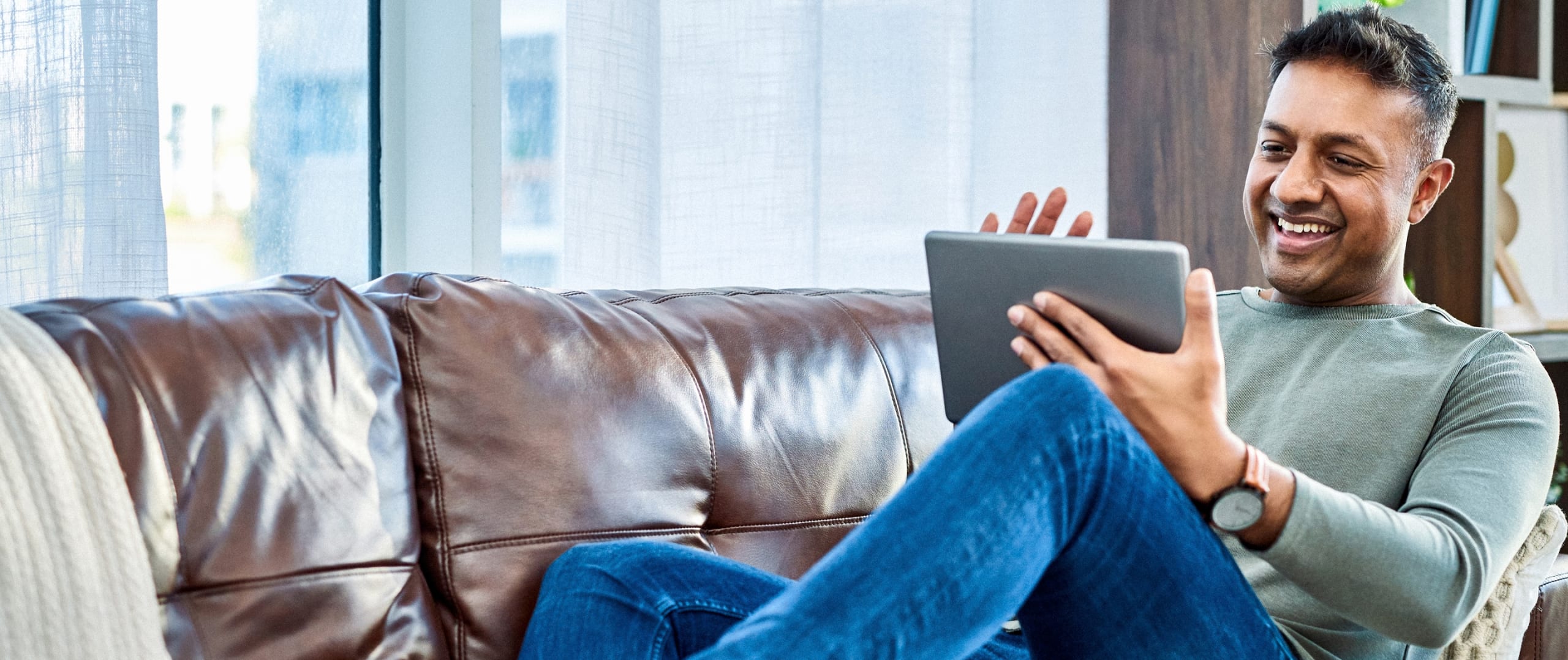 Man Sitting On Couch Using a 
Tablet.png