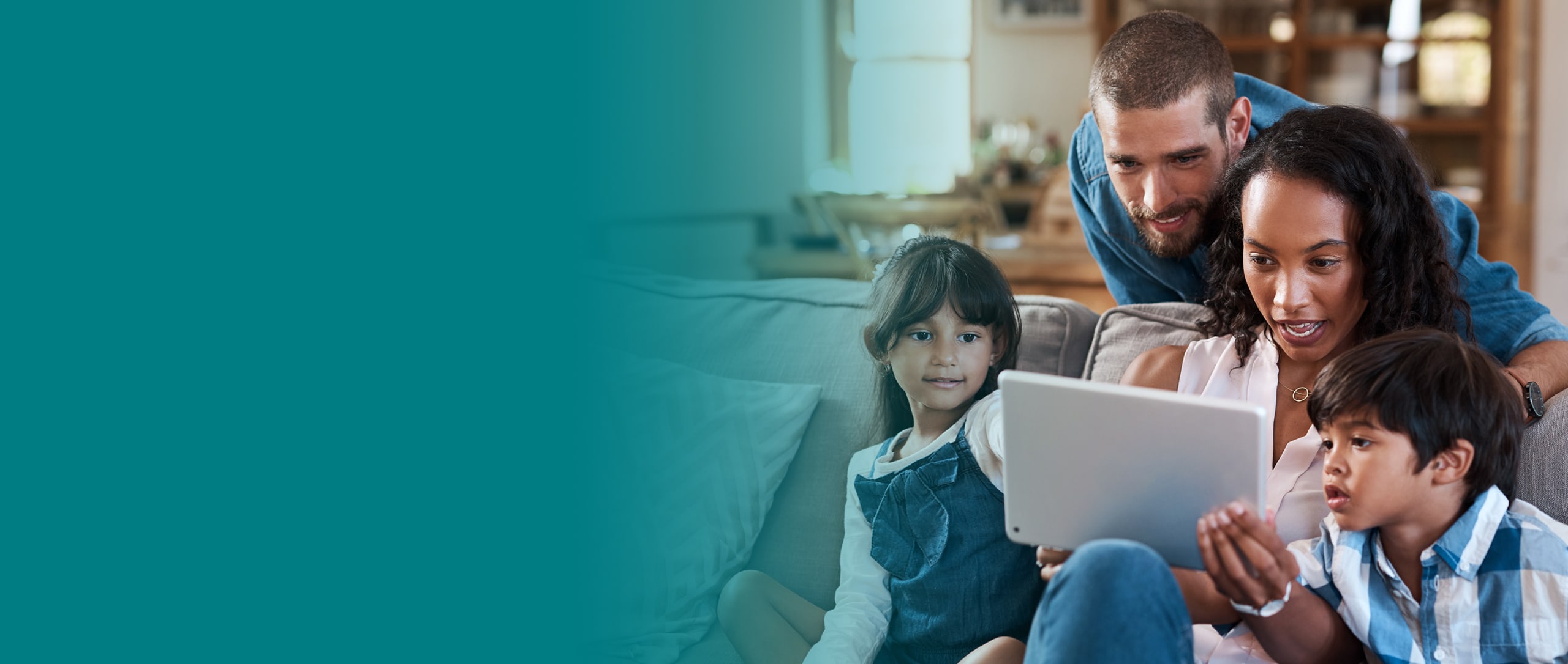 Family sitting on couch looking at iPad