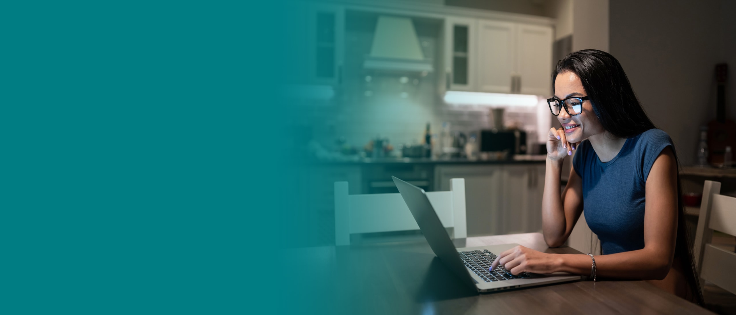 Woman working on laptop on kitchen table