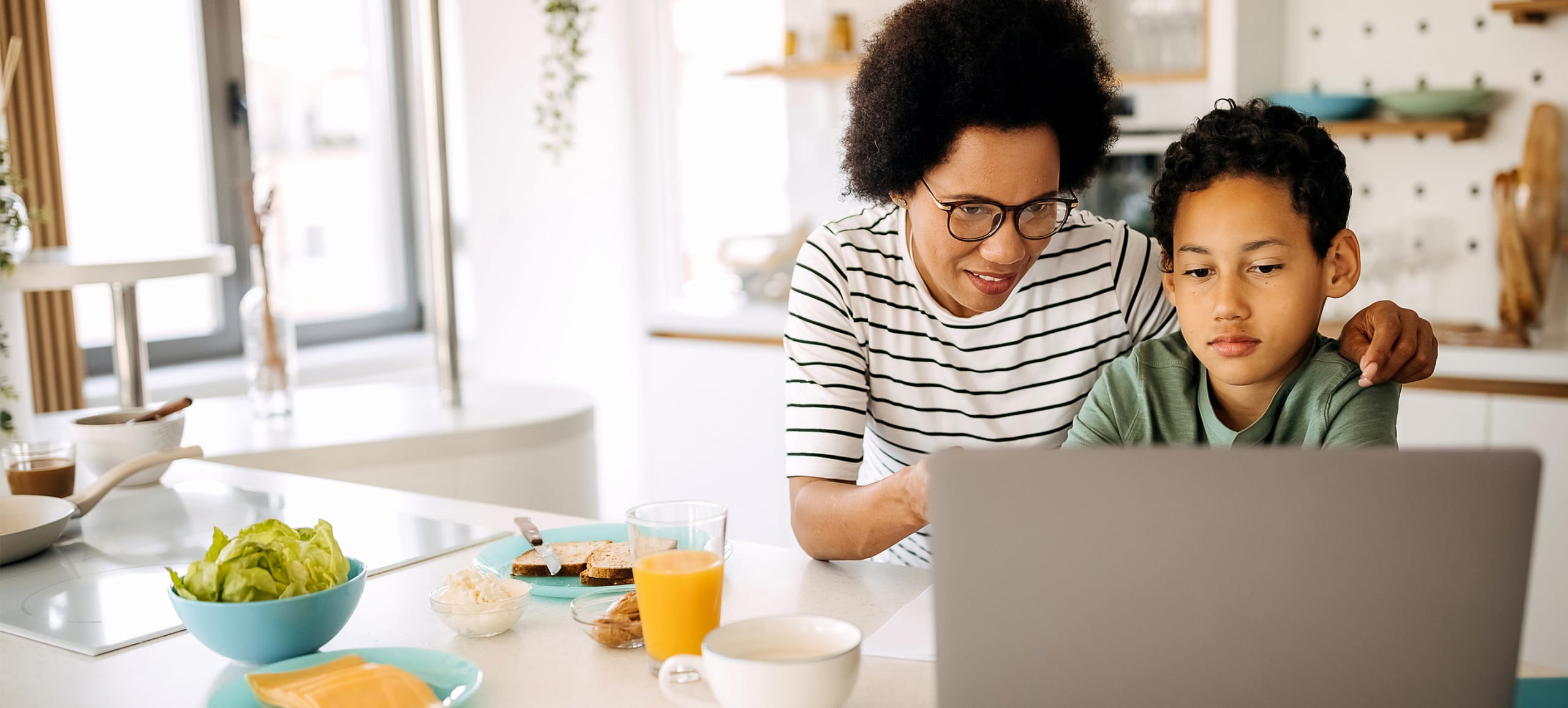 mother helping her son with online learning