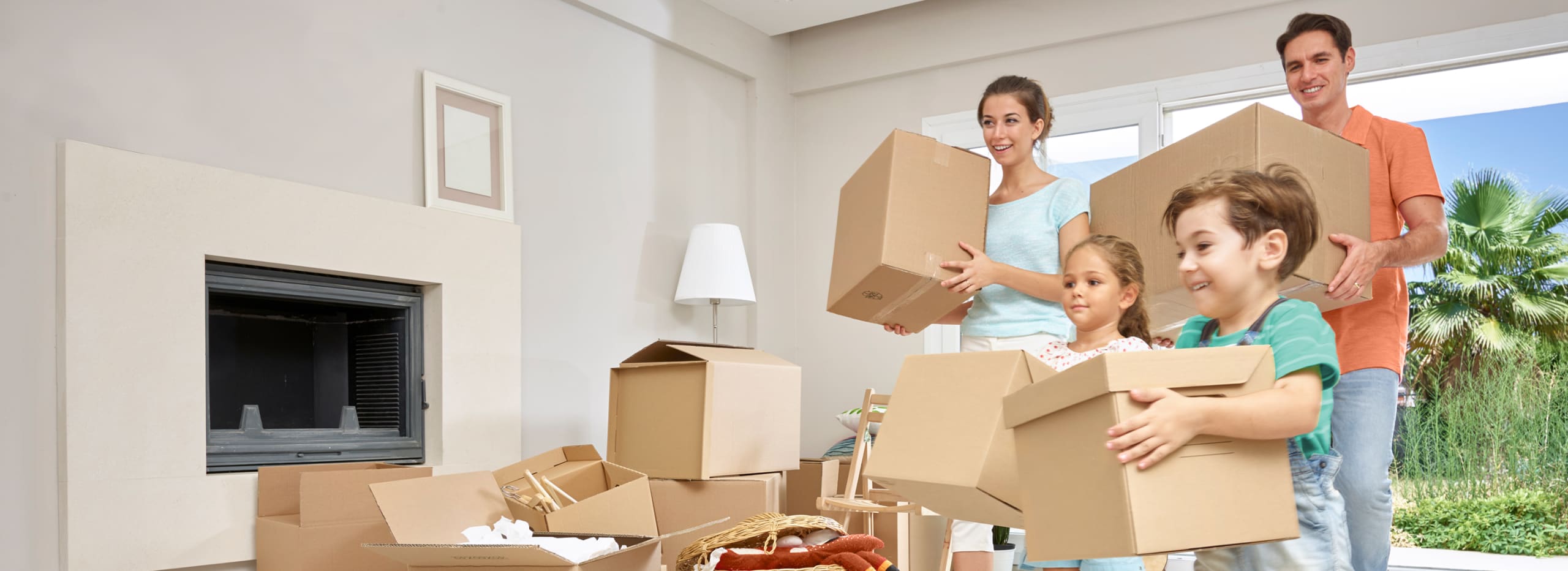 Happy family bringing in their moving boxes