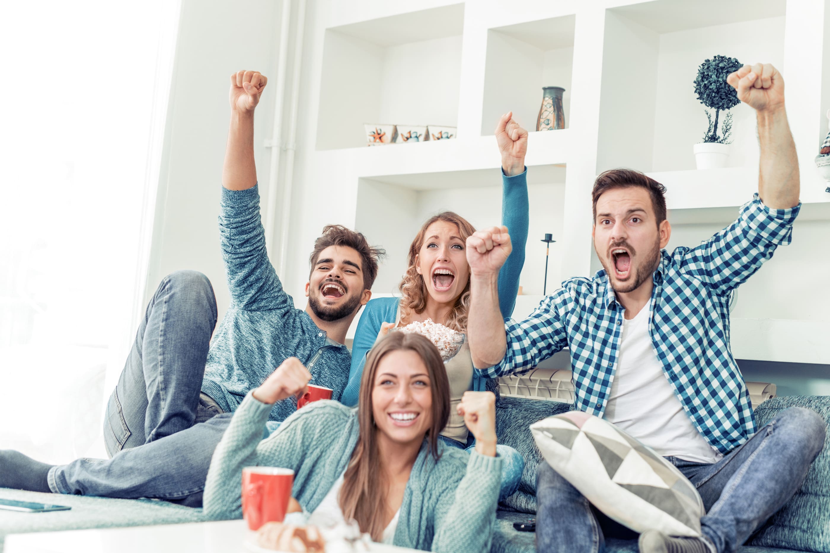 friends watching sports on tv and cheering