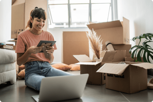 Woman sitting on the floor with moving boxes around her