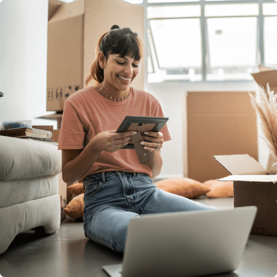 Woman sitting on the floor with moving boxes around her