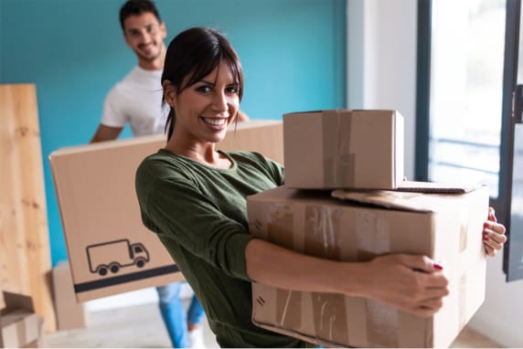 Happy couple moving boxes