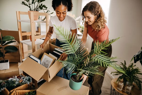 Two ladies packing their things into boxes