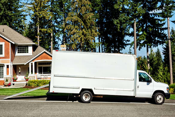 White Moving truck in front of a home