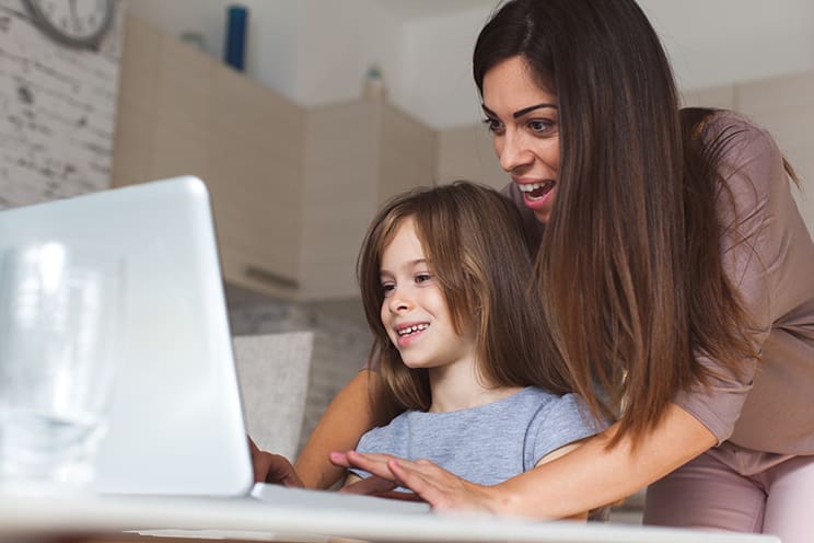 mom helping her kid with the computer