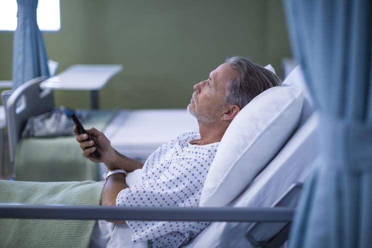 Man in hospital bed watching TV