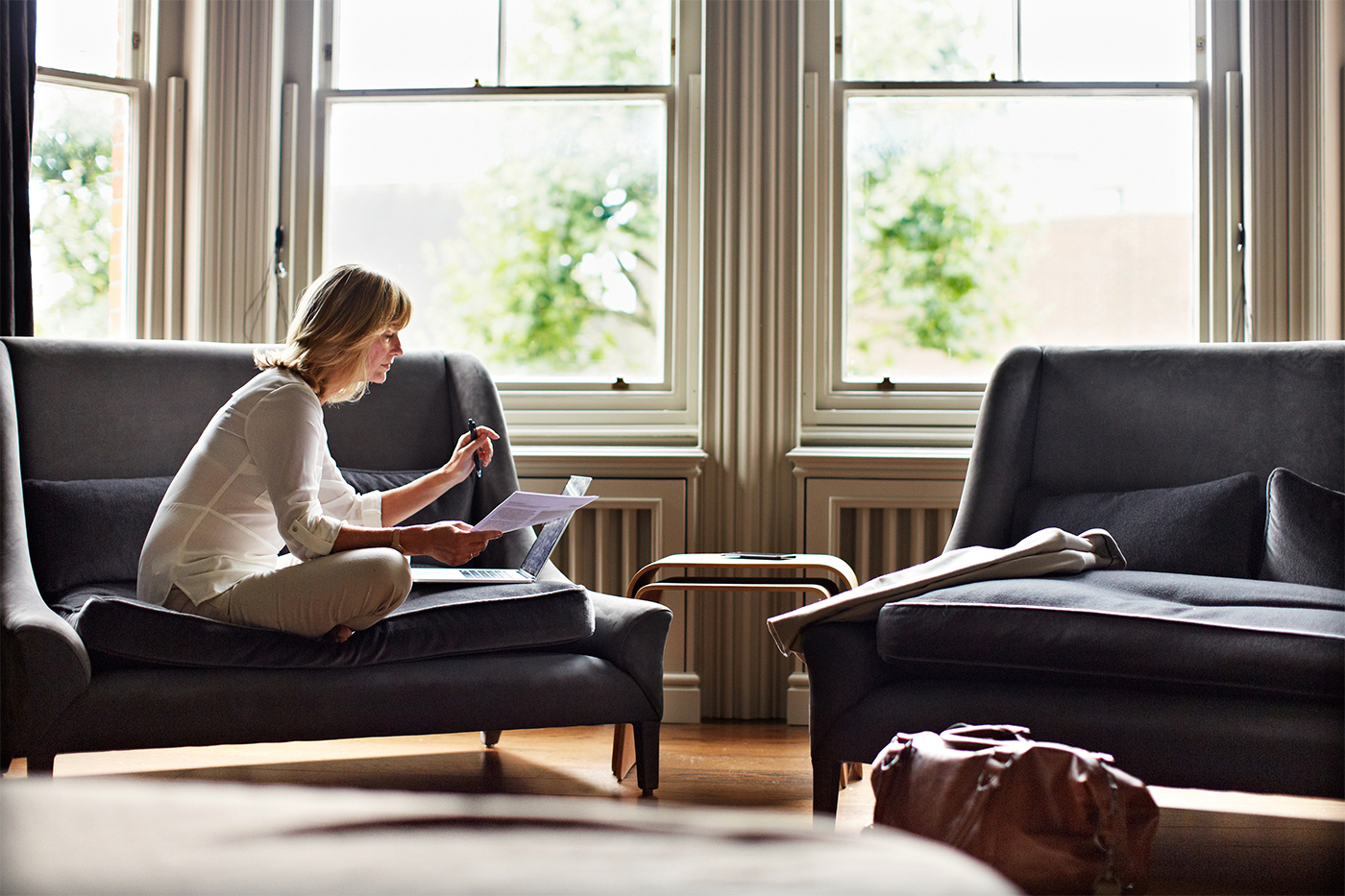 Woman on couch working on laptop