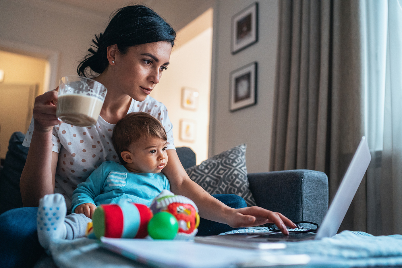 woman with baby on lap, working on laptop