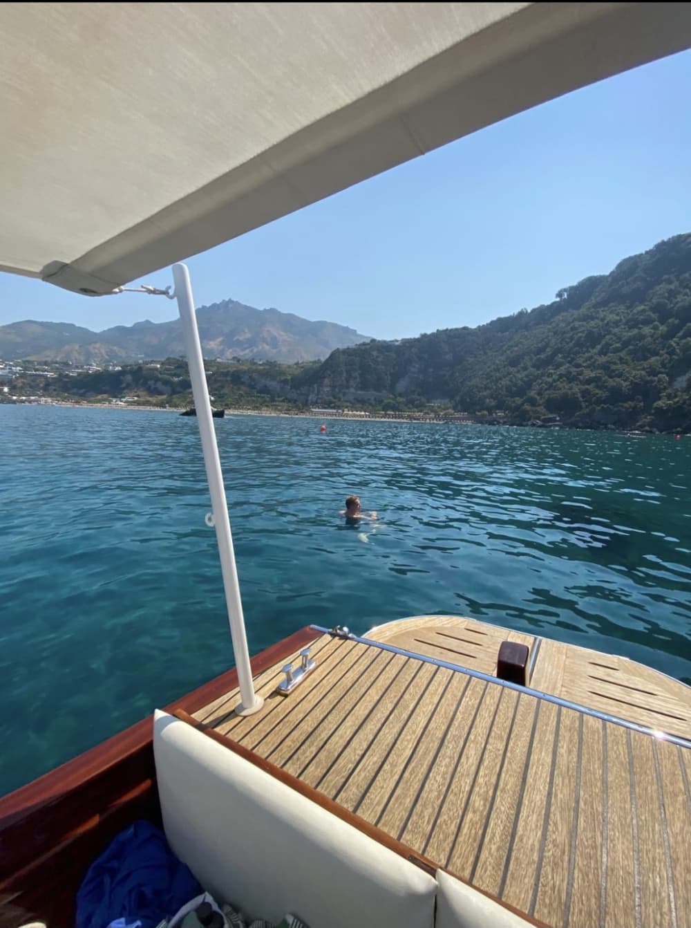 Discover the beauty of Ischia on a mahogany boat, exploring its coasts and secret caves.