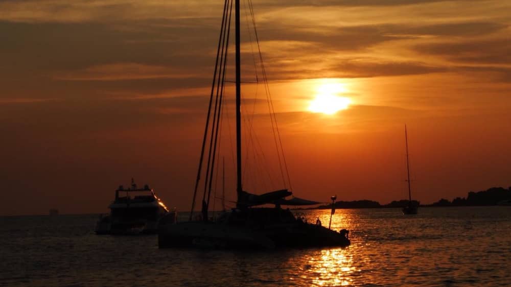 Exclusive sunset aboard a luxurious 14-meter catamaran in the heart of the Maddalena Archipelago with sunset over the Strait of Bonifacio
