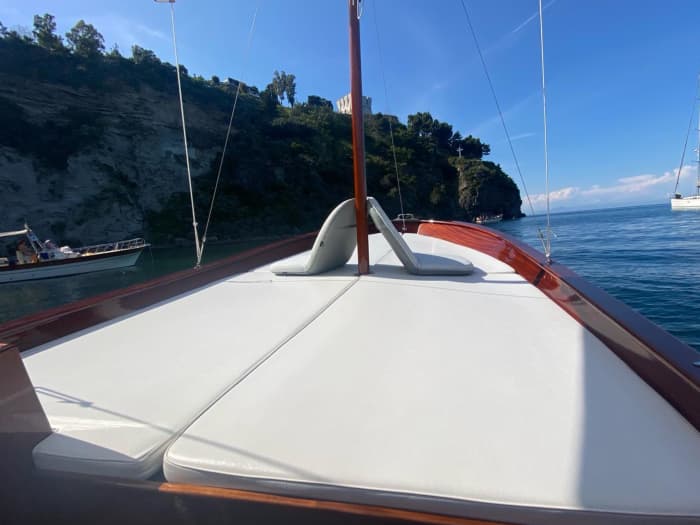 Entdecken Sie die Schönheit von Ischia an Bord eines Mahagoniboots und erkunden Sie die Küsten und verborgenen Höhlen.