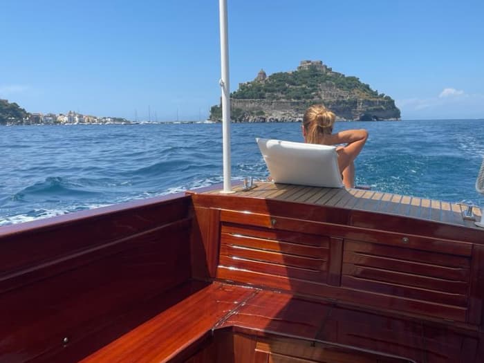 Entdecken Sie die Schönheit von Ischia an Bord eines Mahagoniboots und erkunden Sie die Küsten und verborgenen Höhlen.