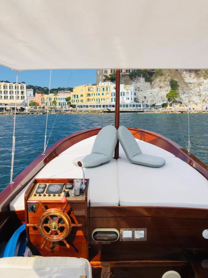 Entdecken Sie die Schönheit von Ischia an Bord eines Mahagoniboots und erkunden Sie die Küsten und verborgenen Höhlen.