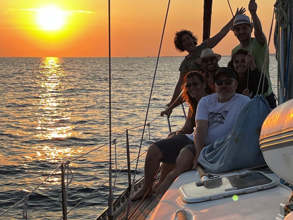 Apéritif au coucher du soleil sur un voilier au large d'Ostie