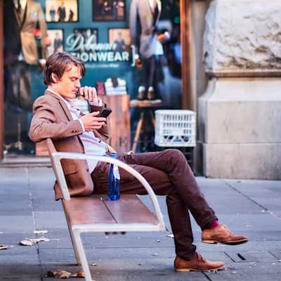 hidden cloudinary watermark tiled on an image of a man sitting on bench