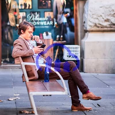 large cloudinary watermark on an image of a man sitting on bench