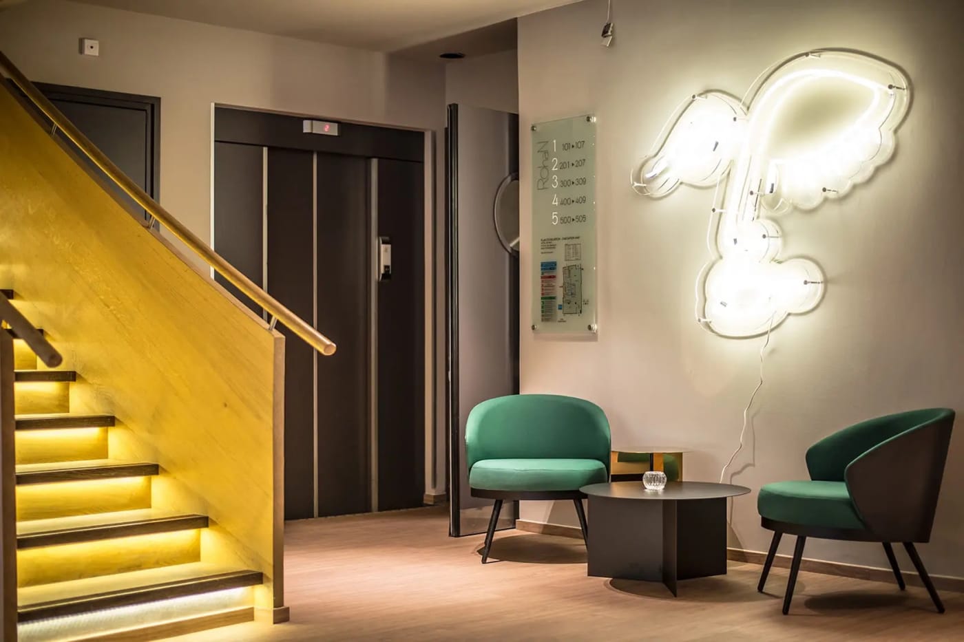 Die Lobby des Hôtel Rohan, lichtdurchflutete Treppe und grüne Sessel