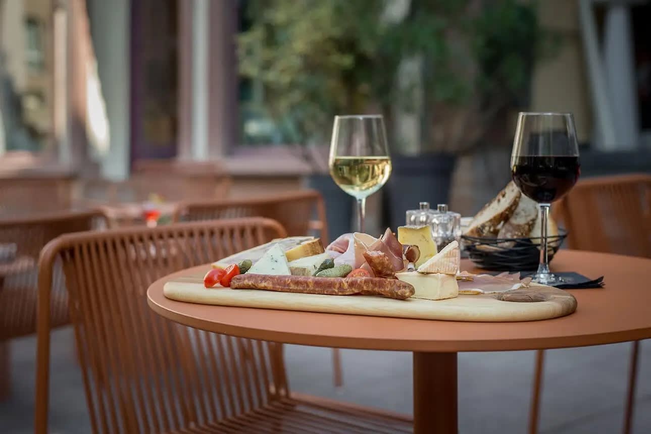 Eine Wurstplatte und Gläser Wein auf der Terrasse des Hôtel Rohan