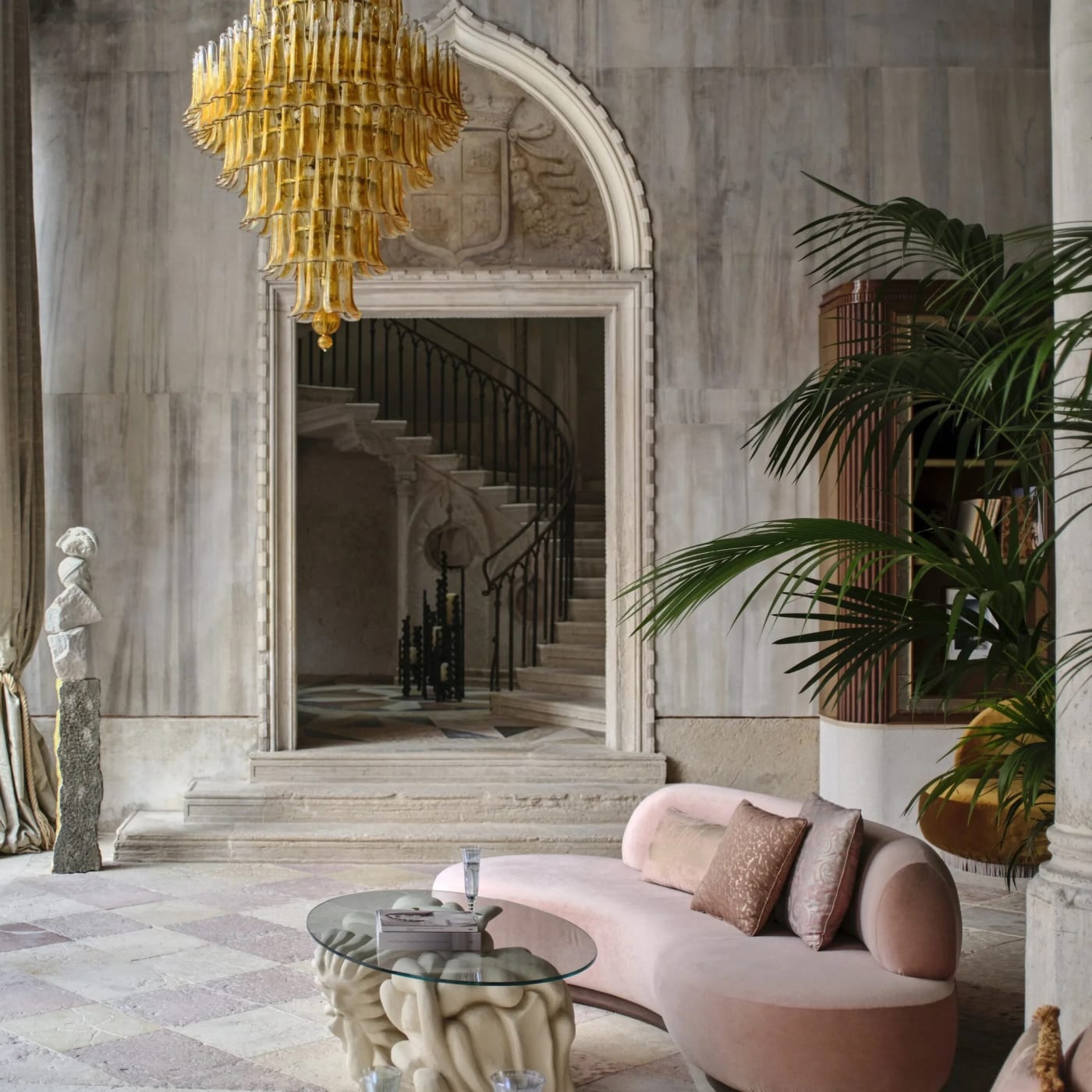 Die Halle des Orient Express Venezia, ihre Treppe, ihr goldener Kronleuchter aus Muranoglas und ein rosa Sofa