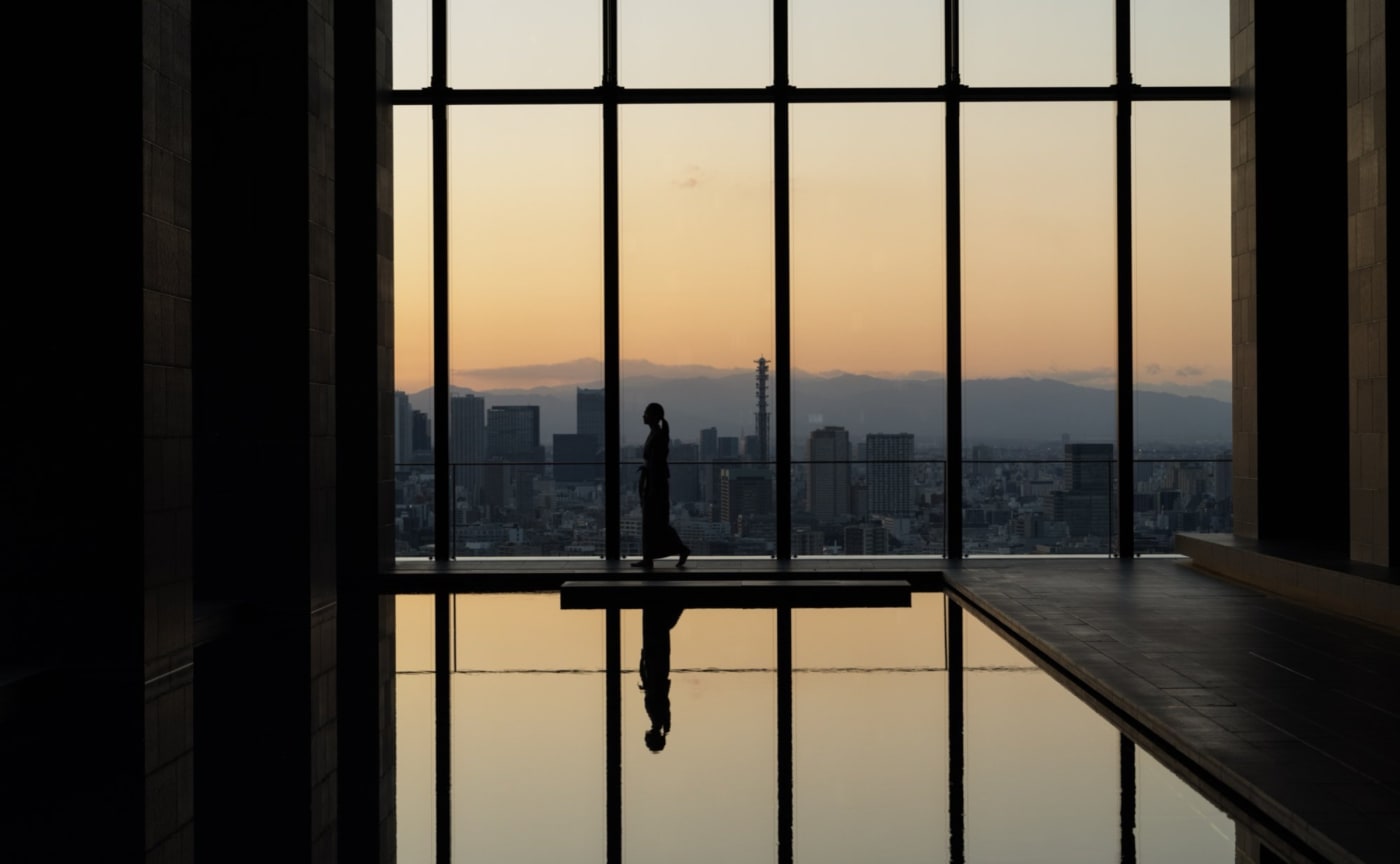 La piscine intérieure de l'Aman Tokyo face à la ville au coucher du soleil