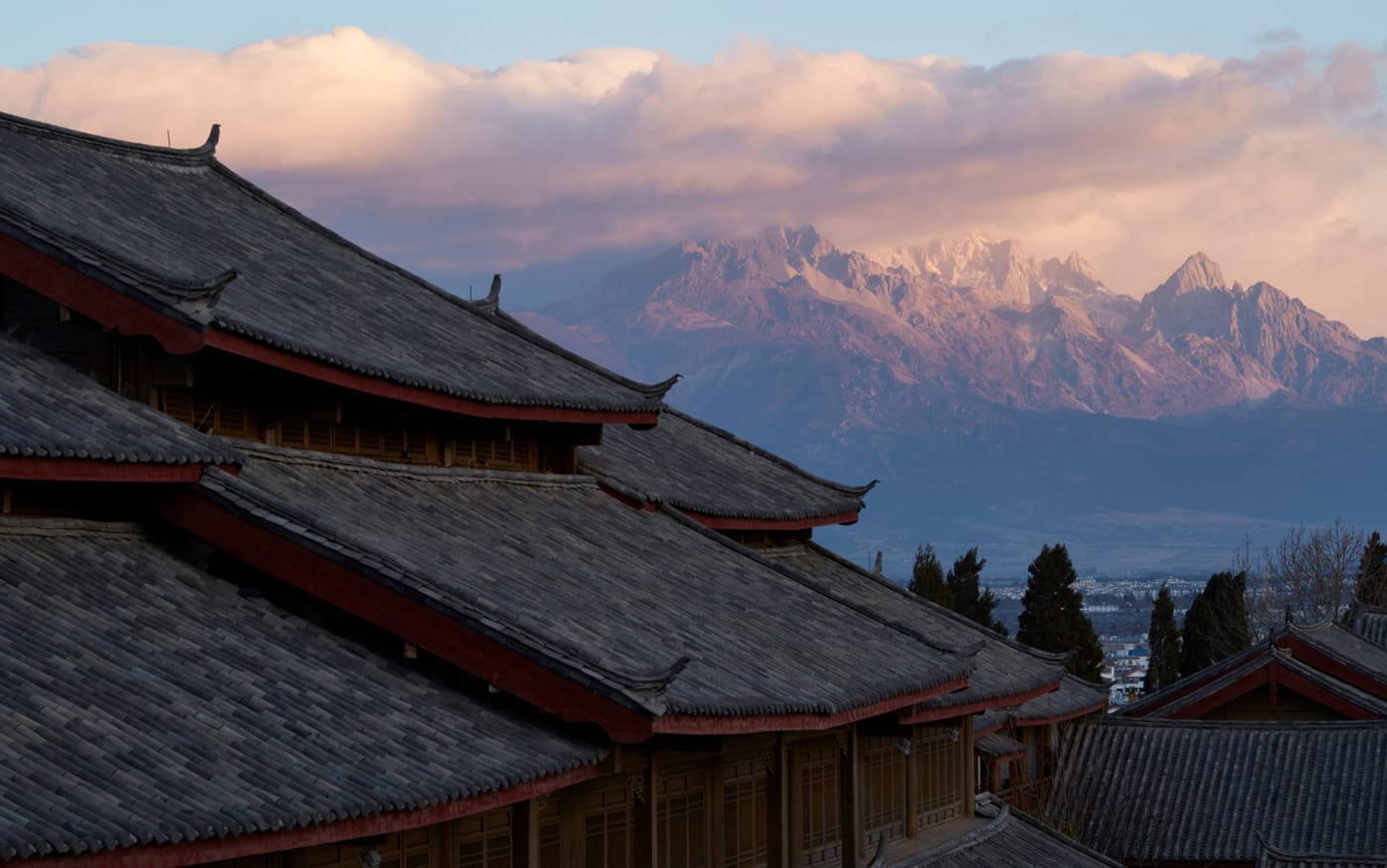 Les toits d'Amandayan à Lijiang devant la montagne enneigée du Dragon de Jade