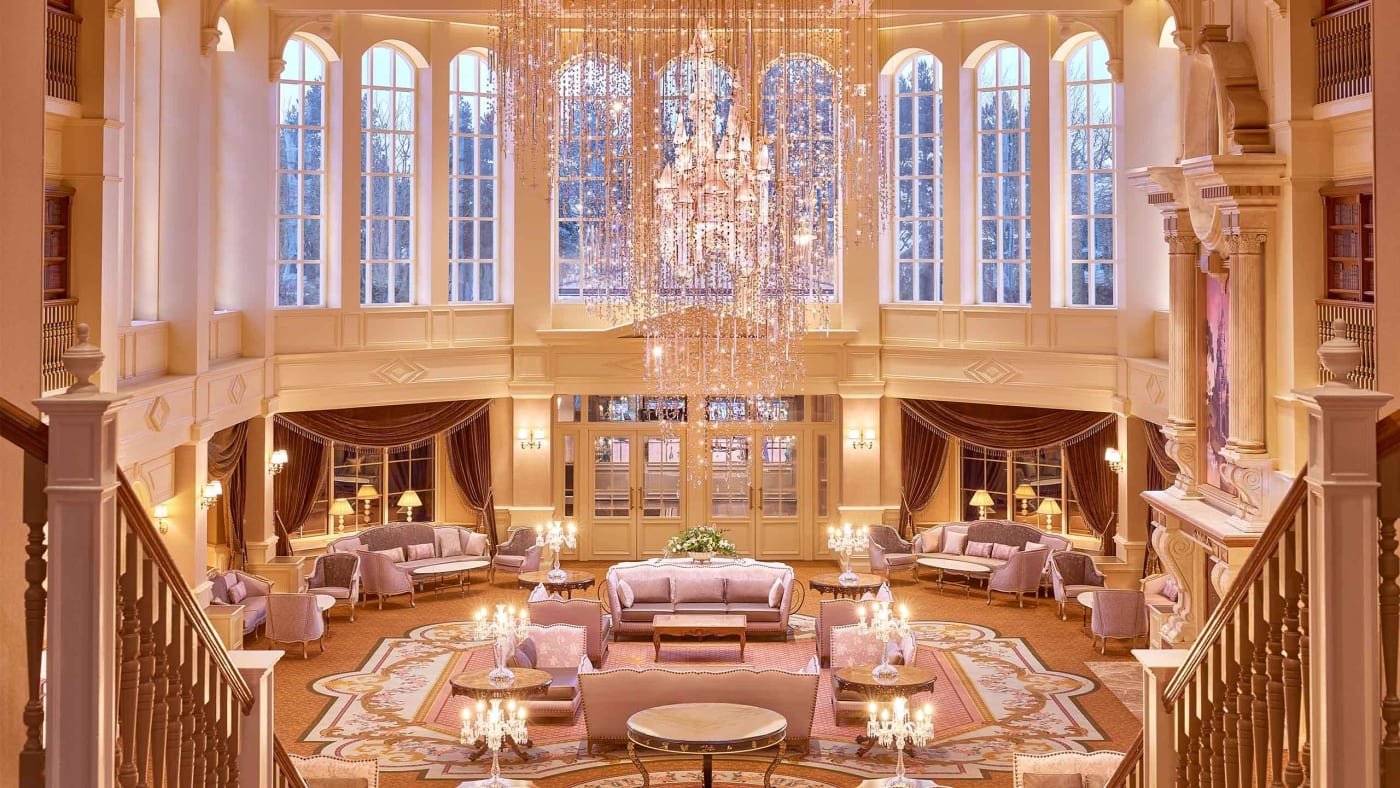 Grand lobby of the Disneyland Hotel at Disneyland Paris, with its crystal chandelier, gilded panelling and tall windows