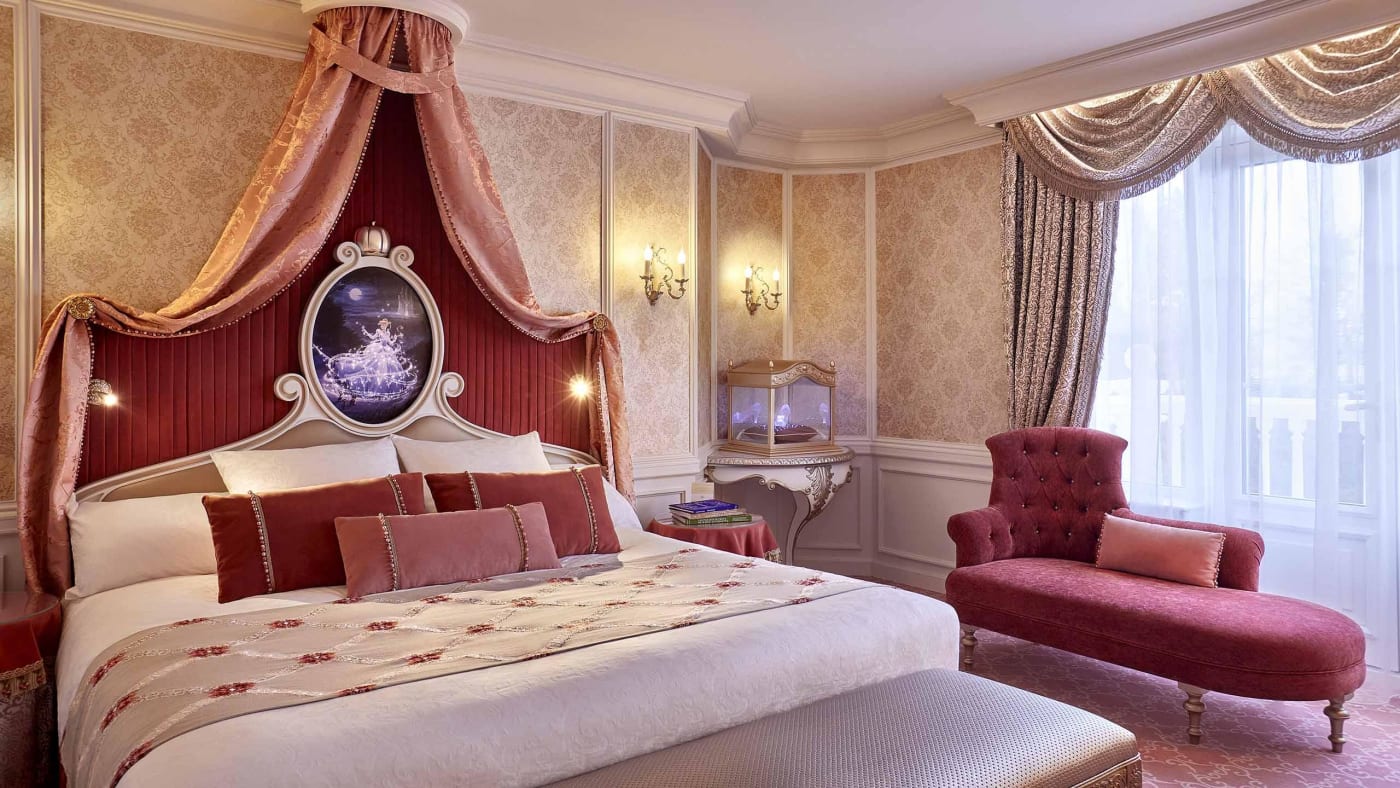 Cinderella Signature Suite at the Disneyland Hotel, with a red four-poster bed and an illuminated carriage above the headboard