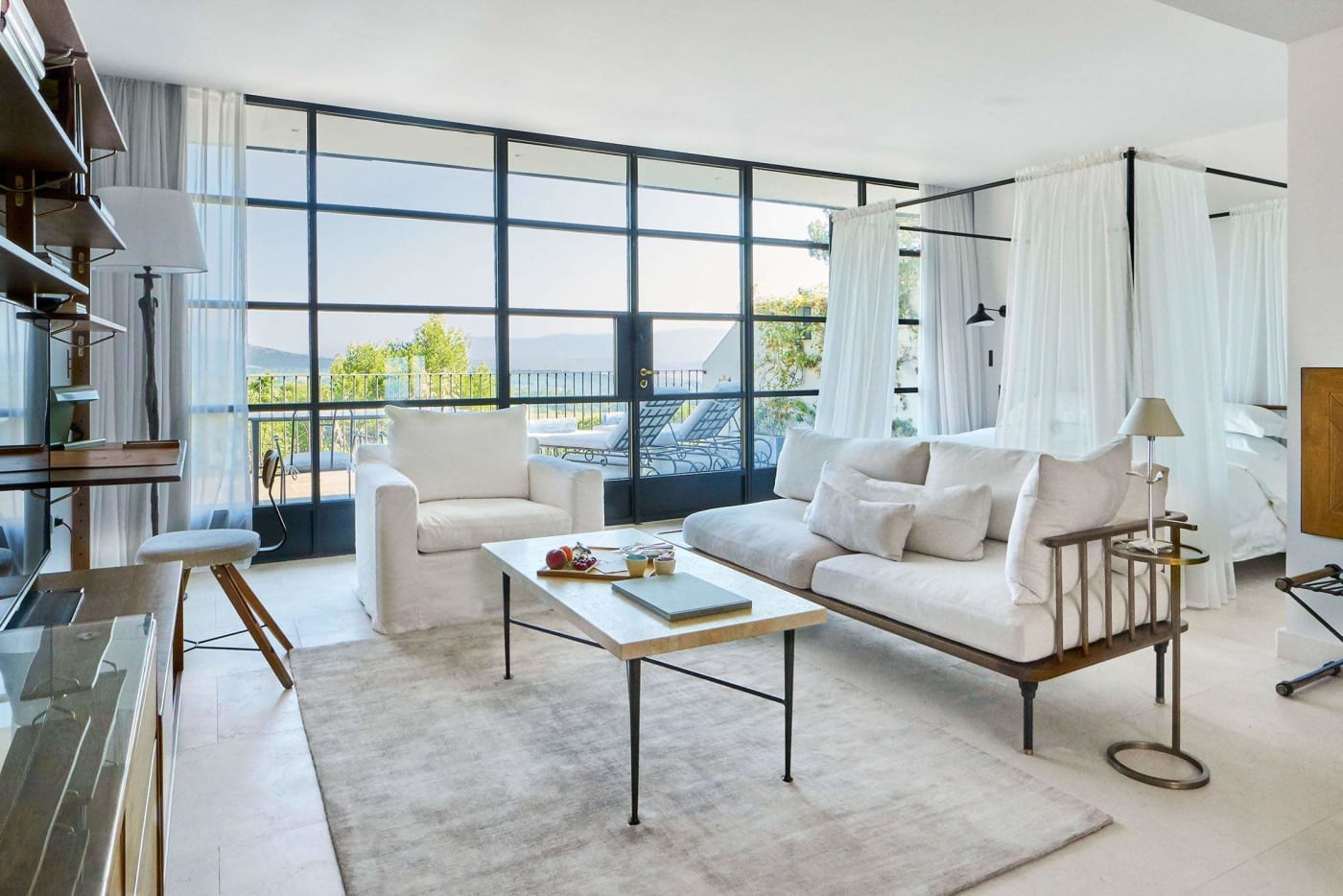 Bright living room of a Suite Pavillon at Villa La Coste, with white sofas and glass doors opening onto the terrace