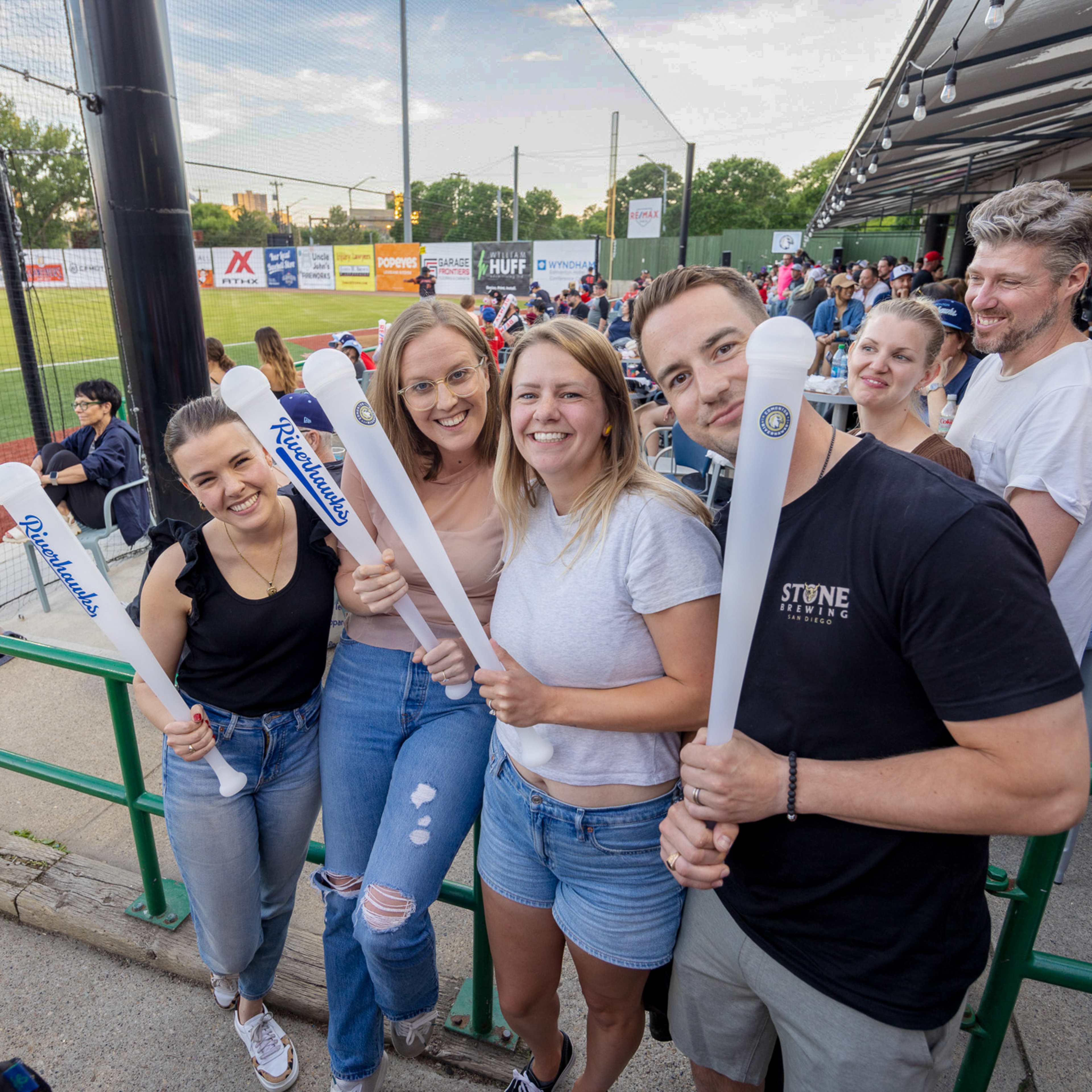 Fans with beer bats smiling for camera