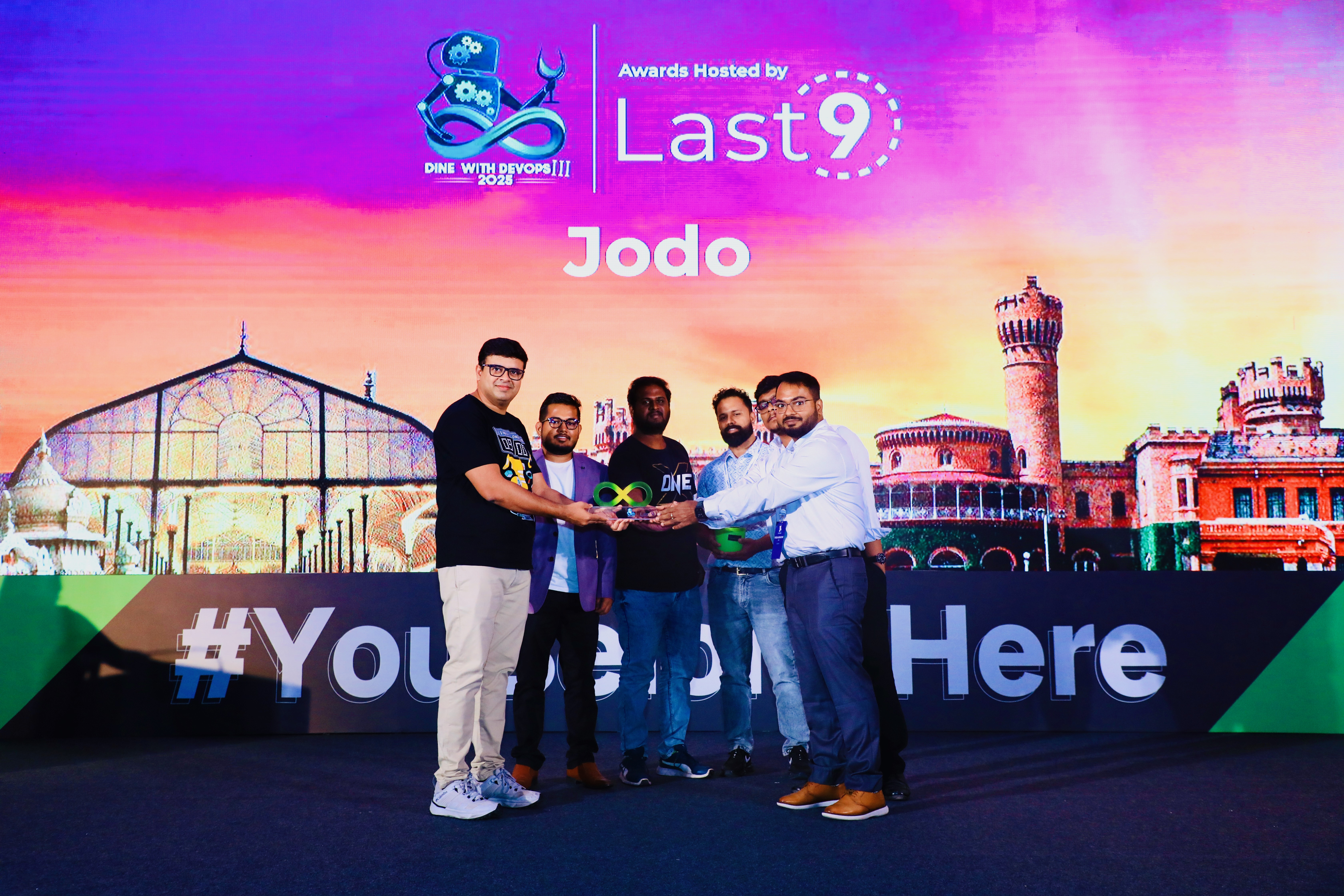 Our team on stage receiving the award, and a close-up of the award shield.