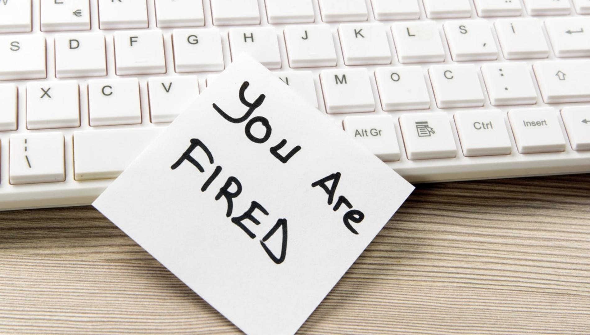 A keyboard with a note on it reading "you are fired"