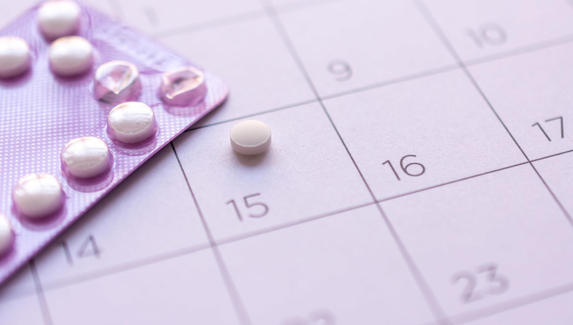 A pack of birth-control pills sitting on a calendar background