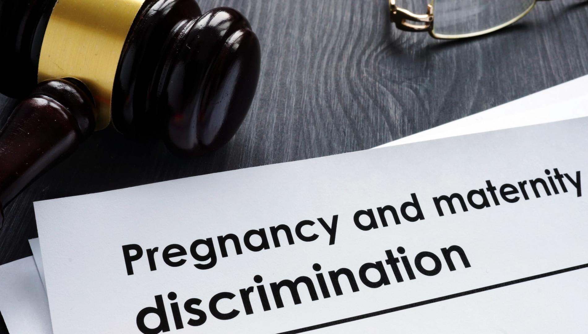 Paper with the heading 'Pregnancy and maternity discrimination' on a desk with a judge's gavel