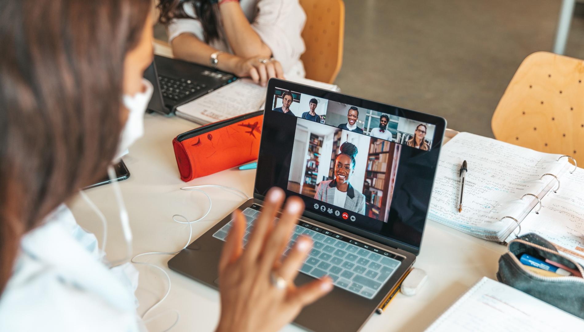 Student on a zoom call waves to others in the meeting.