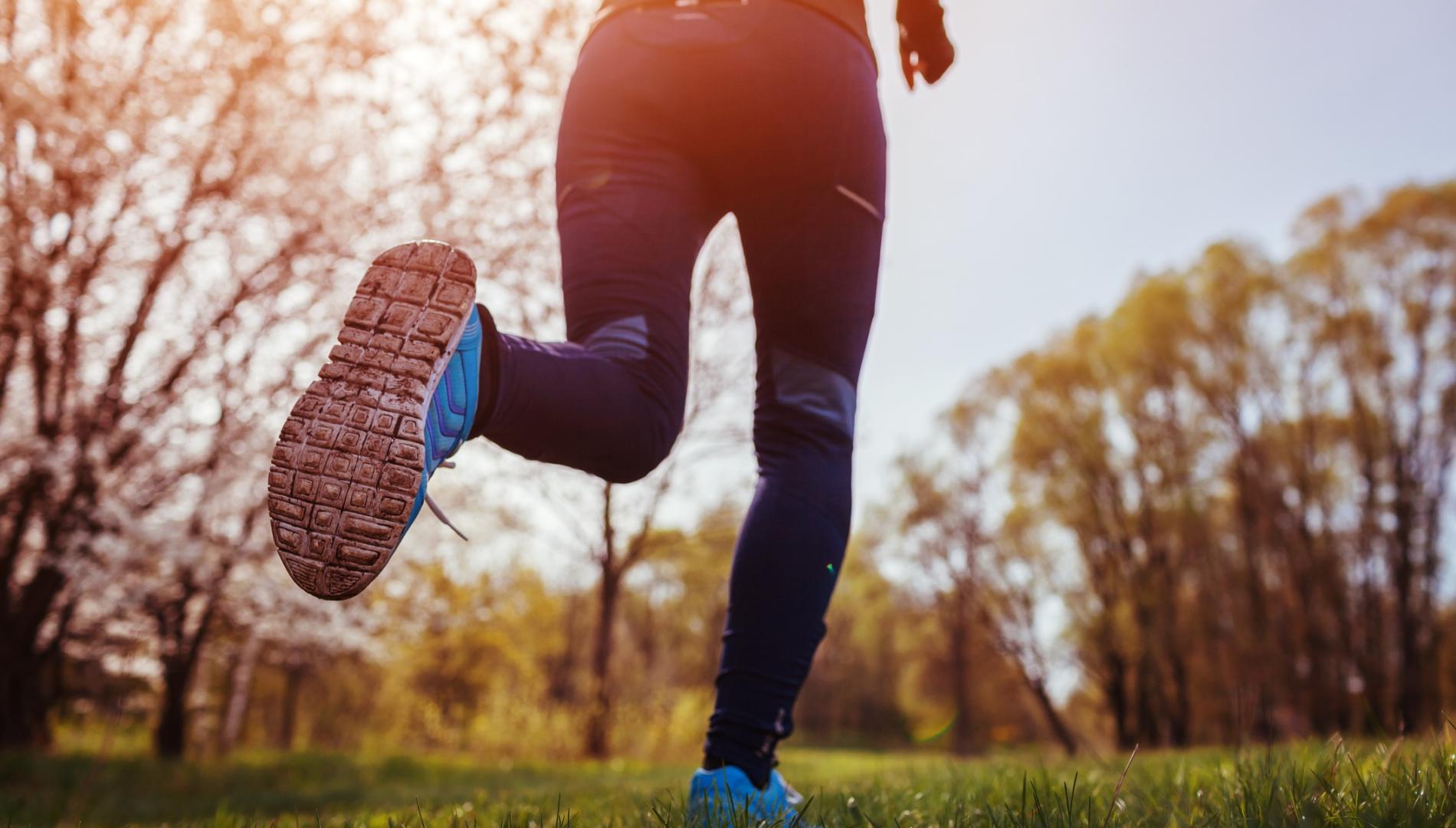 Young woman running in spring forest in the morning.