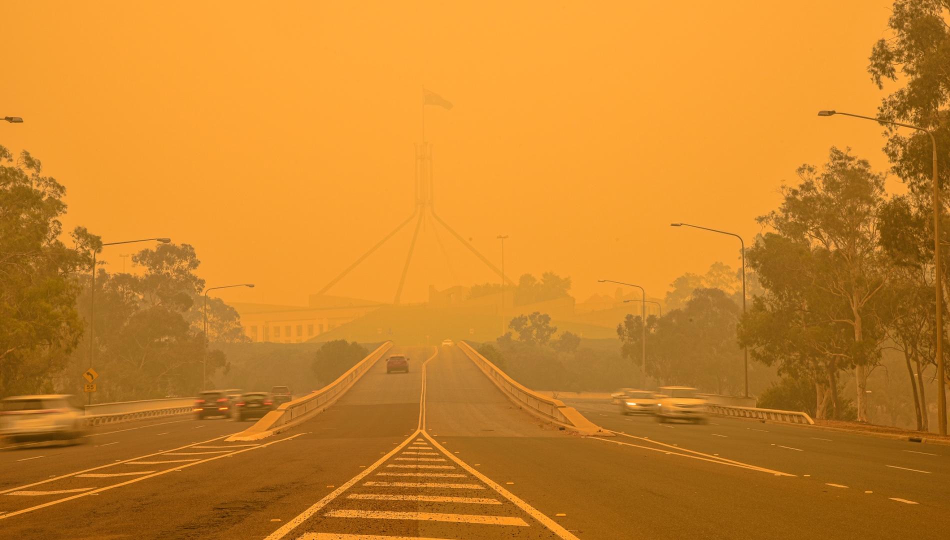 The Australian Parliament house is hardly visible behind a dense smog.