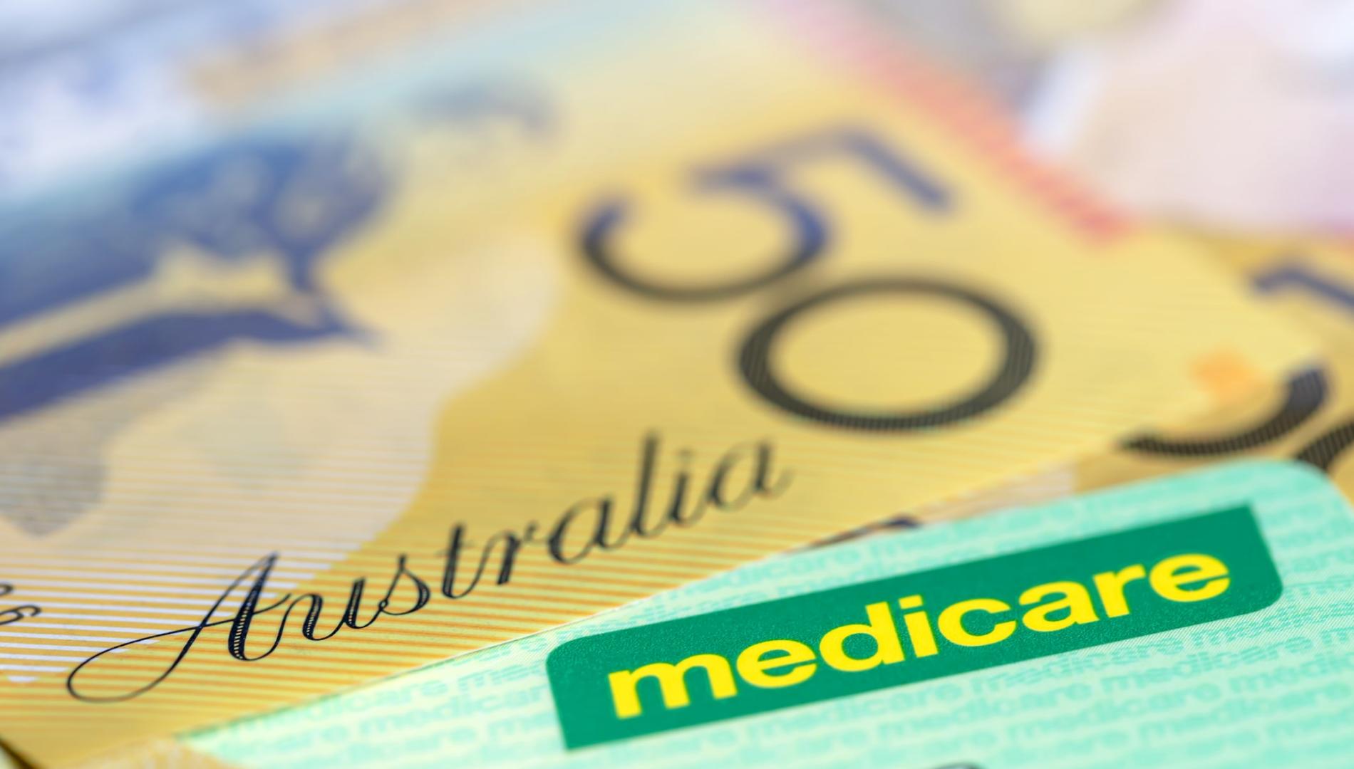 A Medicare card sitting on $50 notes