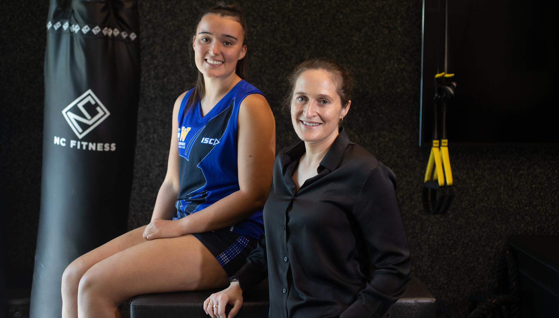 North Melbourne footballer Tricia Cowan and Dr Elise Facer-Childs smiling