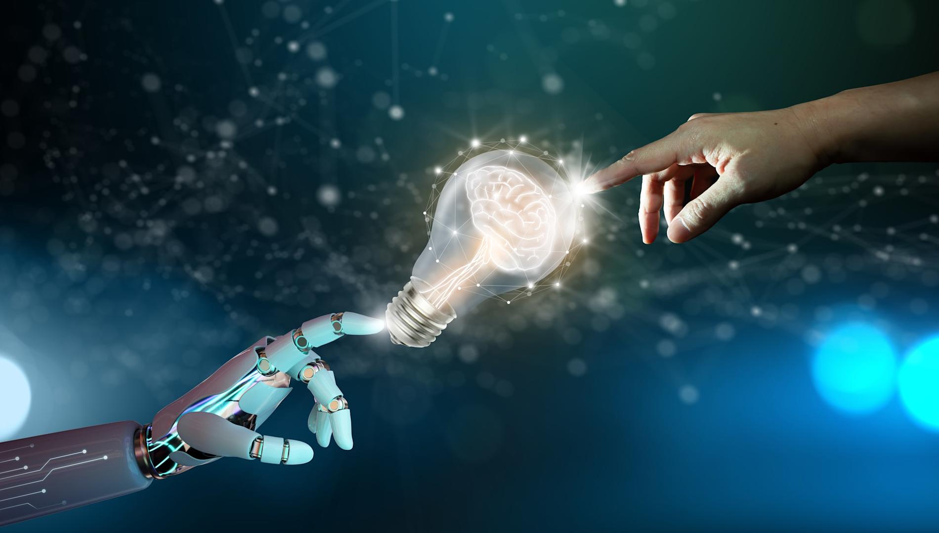 Robot hand and human hand touching a light bulb with a brain inside
