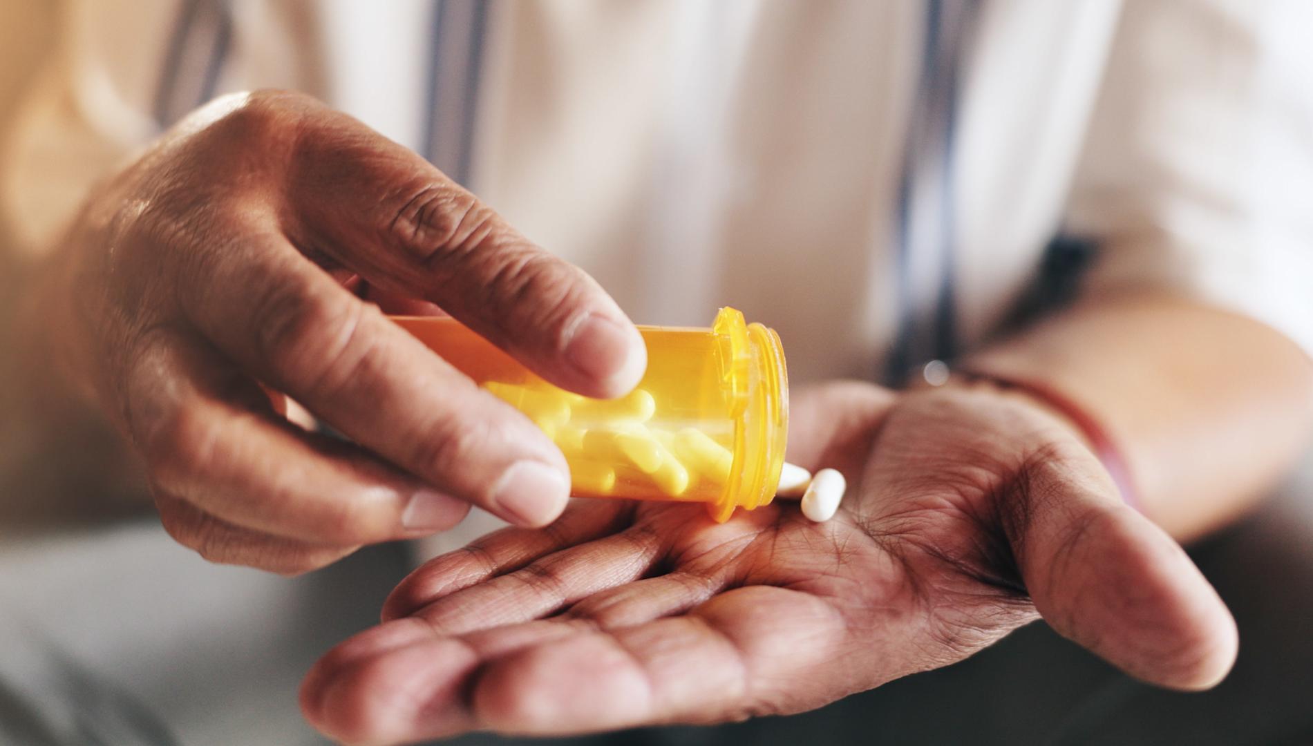 Hands, pills and bottle in closeup for elderly person with drugs