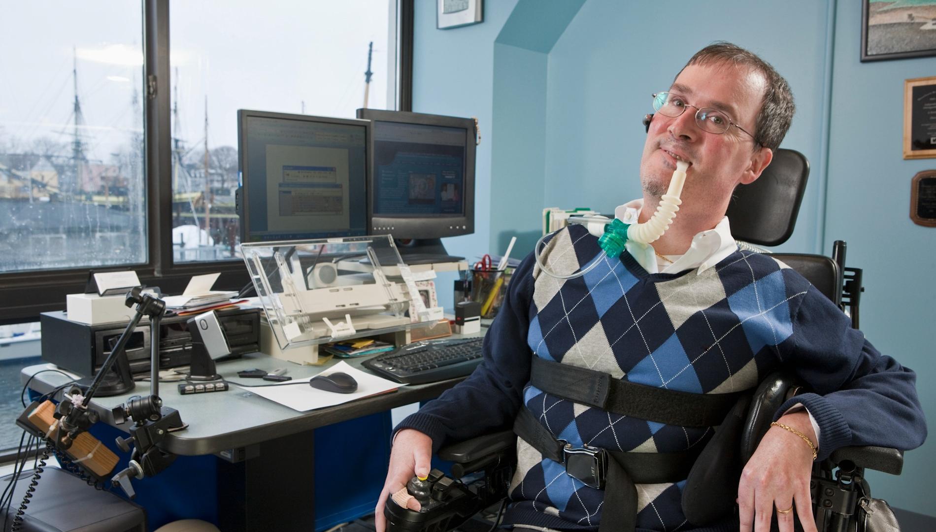 Businessman with Duchenne muscular dystrophy using a breathing ventilator.