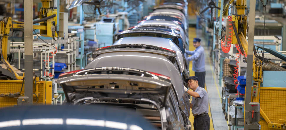 Employees work on the production line of Haima 7X-E electric vehicle at Haima Automobile Haikou Base in China. Photo: Getty Images