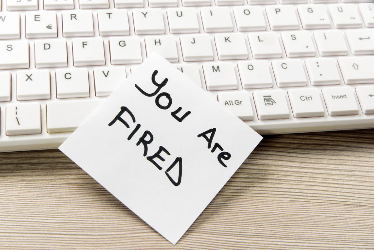 A keyboard with a note on it reading "you are fired"